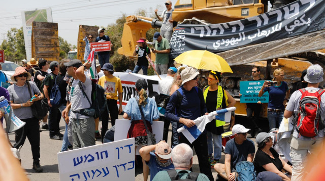 פעילי 'שלום עכשיו' לצד הבולדוזר שהביאו למחאה בחומש (צילום: שלום עכשיו)