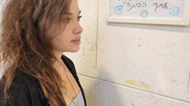 נגה סלה לצד היצירות של אחותה מיכל ז"ל (צילום: המכללה האקדמית תל חי)