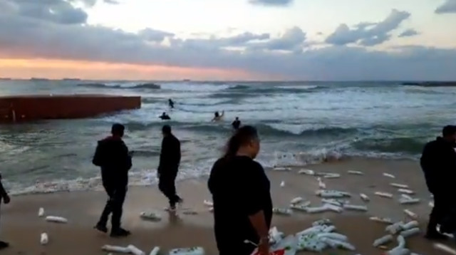 תושבים אוספים ציוד שנפל מהמכולה באשקלון (צילום: צילום מסך רשתות חברתיות לפי חוק 27א לזכויות יוצרים)