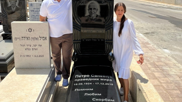 ורוניקה ובעלה אנטולי בקבר של אביה, חסיד אומות העולם, פיוטר סנביץ' (צילום: באדיבות המשטרה)