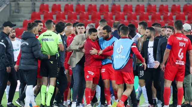 שחקן הפועל באר שבע איתי שכטר מחזיק את שאפי סוליימאנוב (צילום: דני מרון)