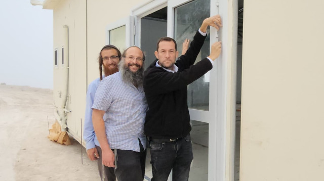 יו"ר המועצה האזורית שומרון, יוסי דגן, קובע מזוזה בישיבה (צילום: רועי חדי)