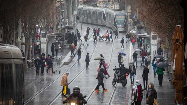 אנשים ברחוב בגשם בירושלים (צילום: אוליביה פיטוסי, פלאש 90)