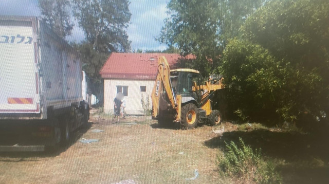 המחפרון בחצר הבית בנהריה (צילום: דוברות המשטרה)