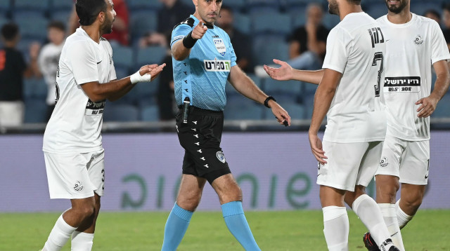 השופט רועי ריינשרייבר בין שחקני מ.ס. אשדוד: אלעד שחף, טום בן זקן, גיל כהן (צילום: ברני ארדוב)