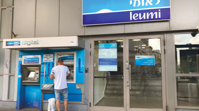 אדם מוציא כסף מכספומט של בנק לאומי (צילום: אבשלום ששוני)