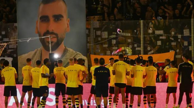 שחקני א.א.ק כשברקע תמונתו של קאצוריס שנרצח (צילום: GettyImages, Pixsell/MB Media)