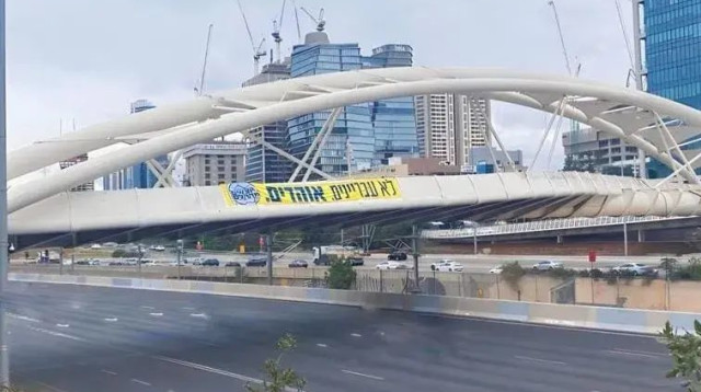 שלטים עם הכיתוב "לא עבריינים. אוהדים" (צילום: מיזם "יוצאים מההלם")