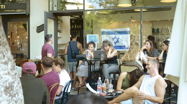 ישראלים בבית קפה בתל אביב במלחמת חרבות ברזל (צילום: אבשלום ששוני)