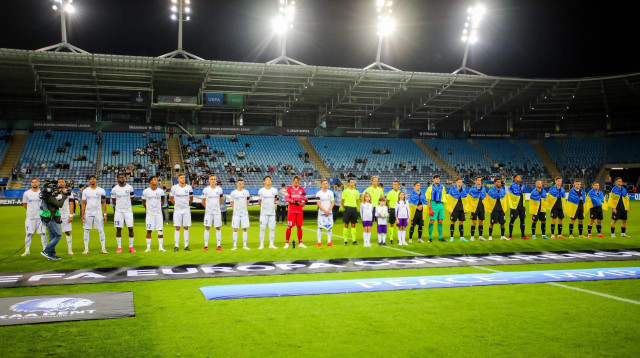 שחקני זוריה לוגנסק (מימין) עטופים בדגלי אוקראינה לצד שחקני גנט (צילום: GettyImages, BARTLOMIEJ WOJTOWICZ/BELGA MAG/AFP)