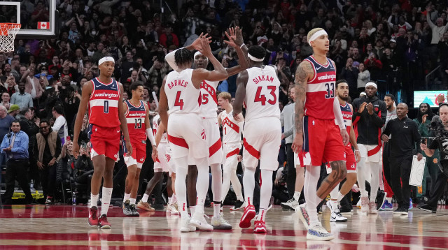 שחקן וושינגטון וויזארדס קייל קוזמה על רקע שחקני טורונטו חוגגים (צילום: רויטרס)