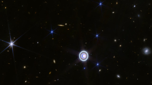 כוכב הלכת אורנוס בתוך פיזור של גלקסיות רקע רחוקות (צילום: נאס"א)