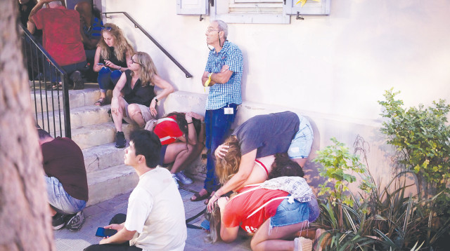 אנשים מסתתרים בזמן אזעקה (צילום: אבשלום ששוני)