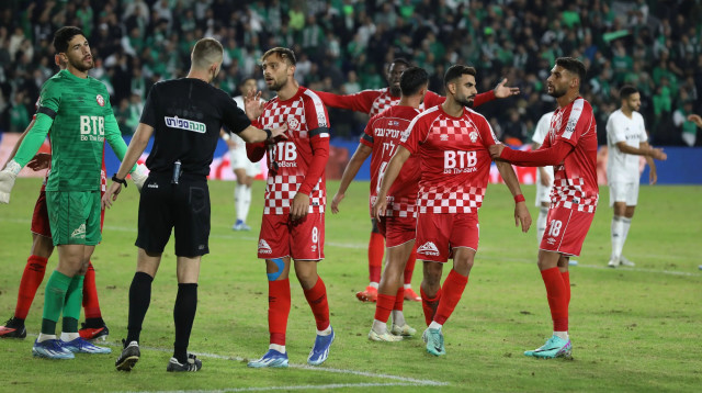 שחקני הפועל חדרה סביב יגאל פריד שופט כדורגל (צילום: שלומי גבאי)