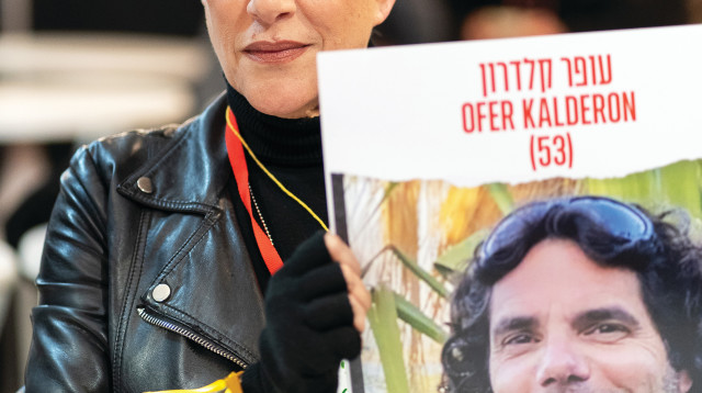 סי היימן ותמונתו של עופר קלדרון החטוף (צילום: אורי בן חיים)