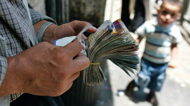 מחליף מטבעות פלסטיני סופר כסף ברחוב ברמאללה  (צילום: רויטרס)