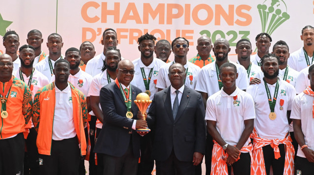 נשיא חוף השנהב אלסאן אואטרה עם הנבחרת והגביע מאליפות אפריקה (צילום: GettyImages)