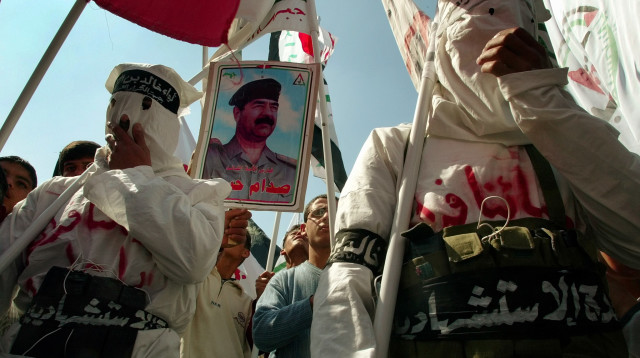 2003. פלסטינים צועדים עם דיוקן של סדאם חוסיין בחאן יונס (צילום: רויטרס)