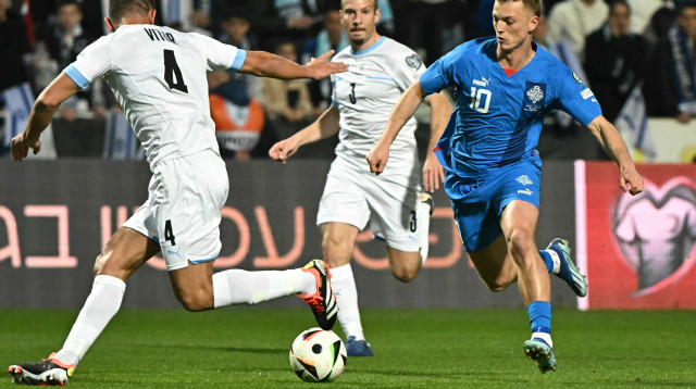 אלברט גודמונדסון שחקן נבחרת איסלנד לפני שון גולדברג, מיגל ויטור שחקני נבחרת ישראל (צילום: GettyImages, ATTILA KISBENEDEK/AFP)