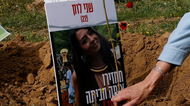 אימה של שני לוק נוטעת עץ לזכרה בשטח המסיבה ברעים (צילום: רויטרס)