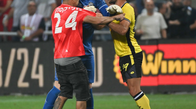 איתמר שבירו שחקן מכבי נתניה בעימות עם אוהד הפועל באר שבע, אופיר מרציאנו מנסה להפריד (צילום: ברני ארדוב)