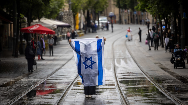 עם דגל ישראל בצפירה ביום הזיכרון לשואה ולגבורה בירושלים (צילום: יונתן זינדל, פלאש 90)