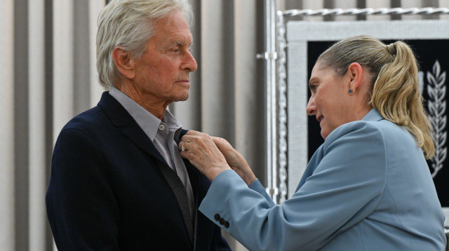 מיכל הרצוג עונדת את סיכת החטופים למייקל דאגלס (צילום: קובי גדעון/לע"מ)