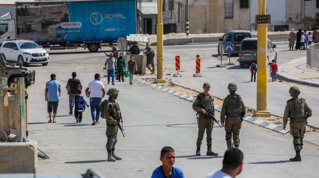 פלסטינים חוצים את הכניסה הדרומית של העיר חברון ביהודה ושומרון (צילום: ויסאם השלמון, פלאש 90)