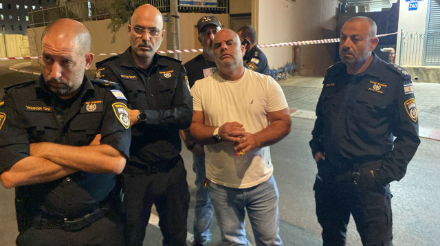 השוטרים בזירה עם החשוד ברצח (צילום: דוברות המשטרה)
