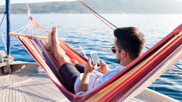 גולש בטלפון בחופשה (צילום: שאטרסטוק)