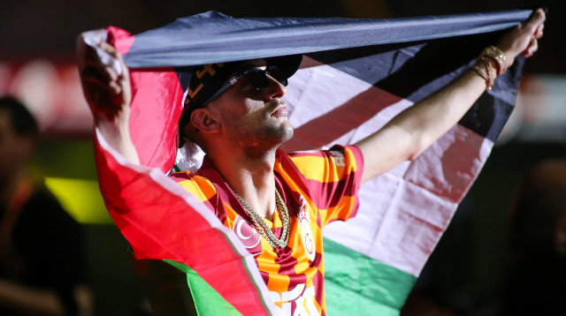 חכים זייש, שחקן גלאטסראיי, עטוף בדגל פלסטין (צילום: GettyImages, Ahmad Mora)