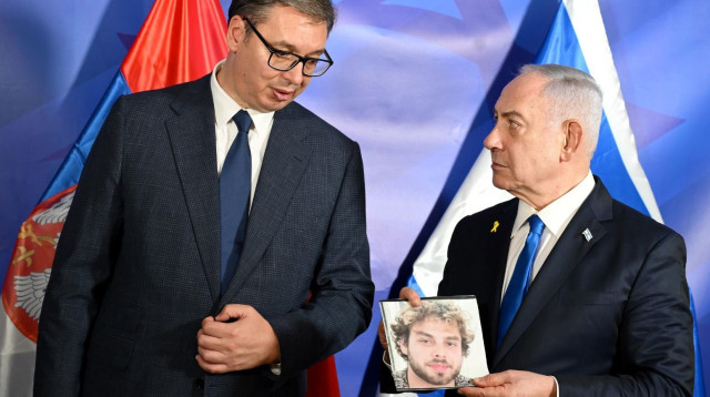 נתניהו אוחז בידו תמונה של אלון אהל בפגישה עם נשיא סרביה (צילום: אבי אוחיון לע"מ)