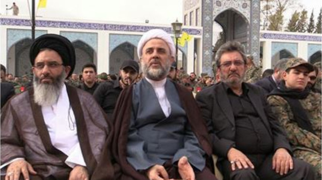 שיח' נביל קאוק (באמצע) כנציג חיזבאללה בטקס בסיידה זיינב, דרום דמשק (צילום: מכון עלמא)