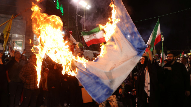 המונים חוגגים בטהרן עם תמונתו של נסראללה לאחר התקיפה האיראנית (צילום: רויטרס)