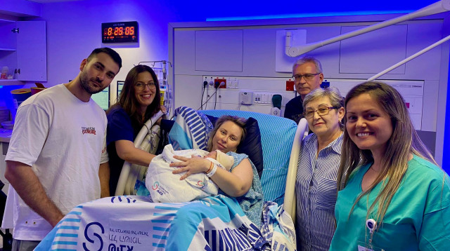  המשפחה המאושרת וצוות חדר לידה בשיבא, התינוק הראשון בשנת תשפ״ה (צילום: דוברות שיבא)