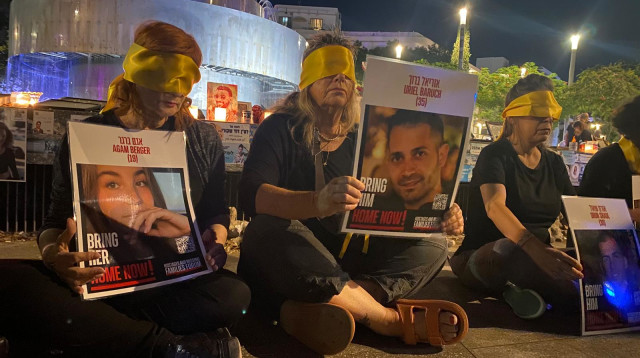 מפגינים בכיכר דיזינגוף עם כיסויי עיניים ותמונות חטופים (צילום: אבשלום ששוני)