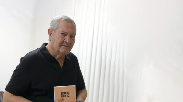 ניצב בדימוס שמעון לוי עם ספרו החדש, "מלחמת בני שרה" (צילום: דודו גרינשפן)