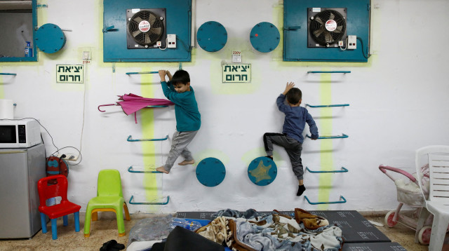 ילדים במקלט בעכו במהלך אזעקה, מלחמת חרבות ברזל (צילום: רויטרס)