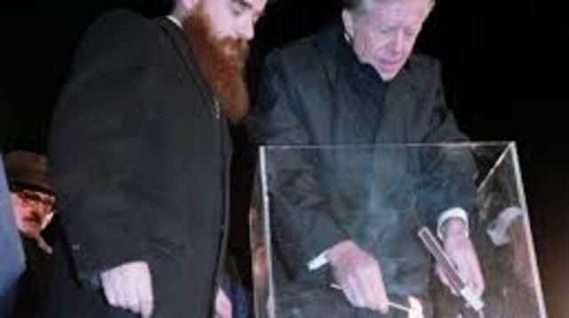 הנשיא לשעבר ג'ימי קרטר מדליק חנוכייה (צילום: אתר הבית הלבן)