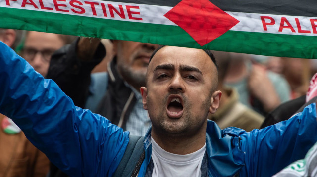 אדם מניף צעיף של פלסטין (צילום: GettyImages, Guy Smallman)