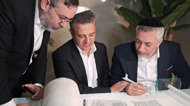 שאמה הכהן כותב אות בספר התורה לעילוי נשמתו של סגן יעקב איליאן ז"ל (צילום: משה כהן)