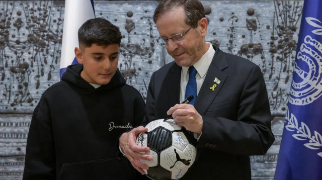 נשיא המדינה יצחק הרצוג עם אחד מנפגעי הרקטות במג'דל שמס (צילום: אבי קנר)