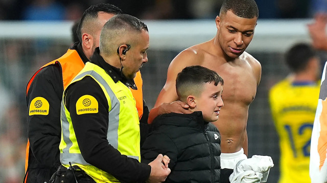 קיליאן אמבפה שחקן ריאל מדריד מעניק חולצה לאוהד צעיר (צילום: GettyImages)