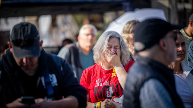 ישראלים בכיכר החטופים צופים בשחרור עופר קלדרון, קית' סיגל וירדן ביבס (צילום: יונתן זינדל, פלאש 90)