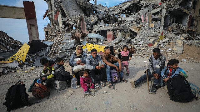 משפחה פלסטינית ליד הריסות ביתה בעזה (צילום: רויטרס)