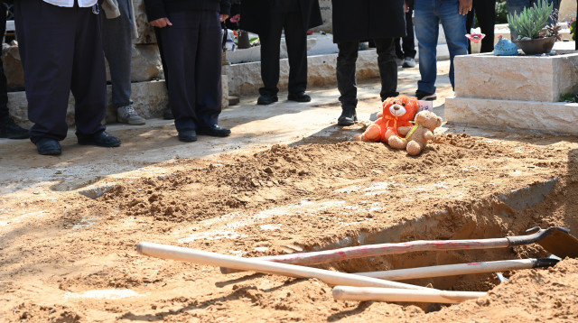 שתי בובות של דובים. בהלוויה של שירי, אריאל וכפיר ביבס (צילום: איתן אונר)