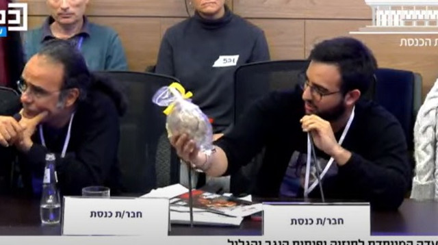 יותם כהן, אחיו של החטוף נמרוד כהן מעניק לשר שיקלי פיתה עטופה בסרט צהוב (צילום: דוברות הכנסת)