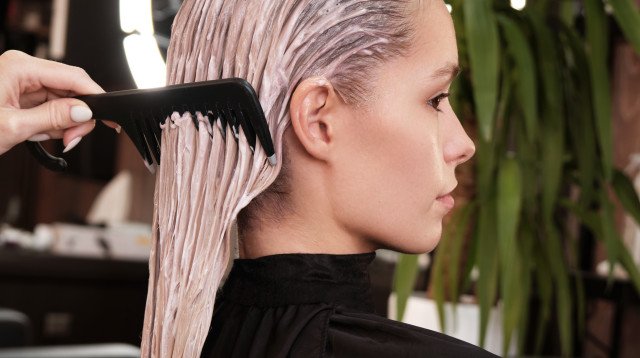 אישה צובעת את השיער במספרה (צילום: שאטרסטוק)
