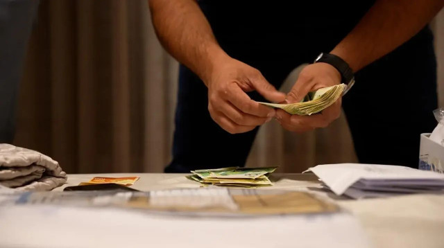 נציגי משטרת ישראל סופרים מזומן במסגרת מעצר (צילום: אתר רשמי, דוברות המשטרה)