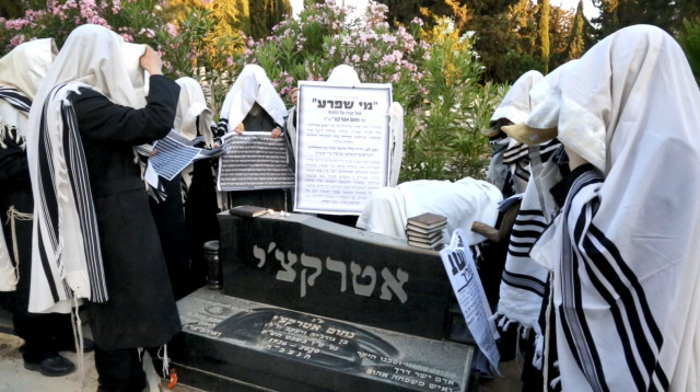 טקס הטלת קללה יהודי על קברו של אביו של היזם יעקב אטרקצ' (צילום: מתוך רשתות לפי סעיף 27 א על פי זכויות יוצרים)